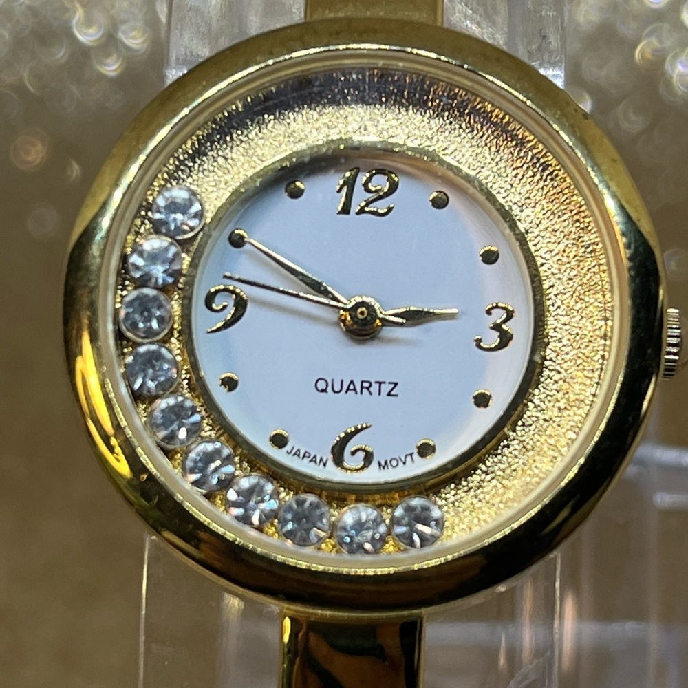 A beautiful bangle bracelet watch! With moving gems! Gold tone classic! 7 1/4